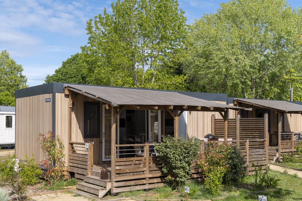 Bungalow en bois dans un parc verdoyant.