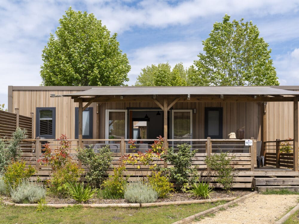 Chalet en bois avec terrasse fleurie.