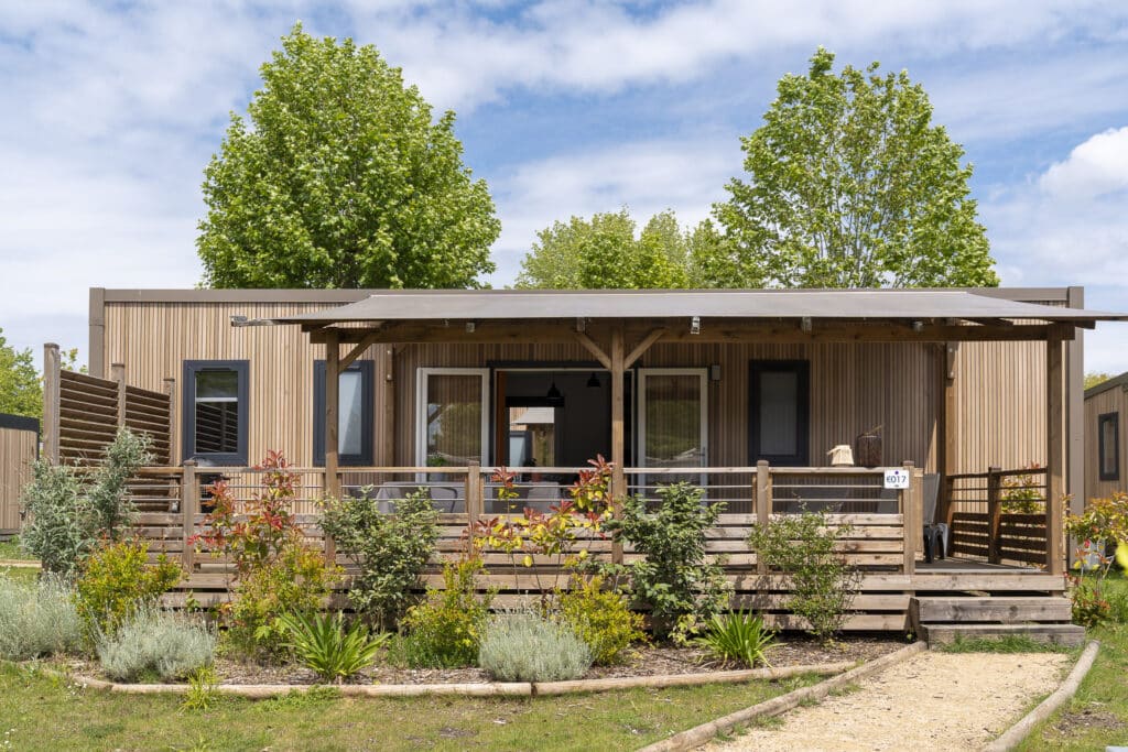 Chalet en bois avec terrasse fleurie.