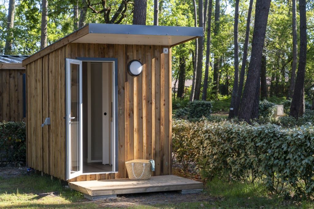 Cabane en bois dans la forêt avec porte ouverte.